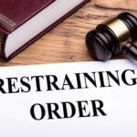 GOP Rep’s Wife Orders Restraining Order After Disturbing Allegations gavel, legal book, and restraining order document on wooden desk