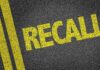 Major Recall Alert: Seats Shifting Mid-Drive yellow recall text on asphalt with double road lines