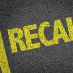 Major Recall Alert: Seats Shifting Mid-Drive yellow recall text on asphalt with double road lines