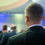Details LEAKED After CIA Director’s Mysterious Moscow Trip Man with earpiece at a crowded event.