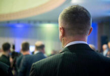 Man with earpiece at a crowded event.
