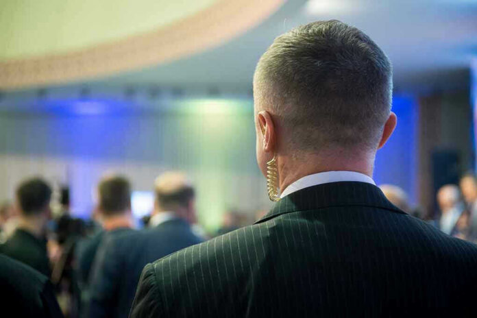 Man with earpiece at a crowded event.
