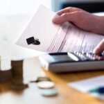 Hands calculating student loan with document and calculator