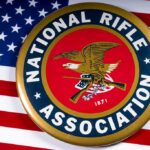 Judge REVOKES 90-Year Gun Ban – 2nd Amendment Stunner NRA emblem on American flag background