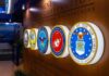 Military department seals displayed on a wall