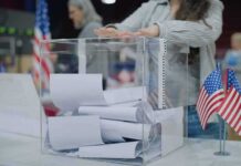 Electoral College Under Fire – Dems Roll-Out NEW Plan Person casting a ballot into a clear box at a polling station