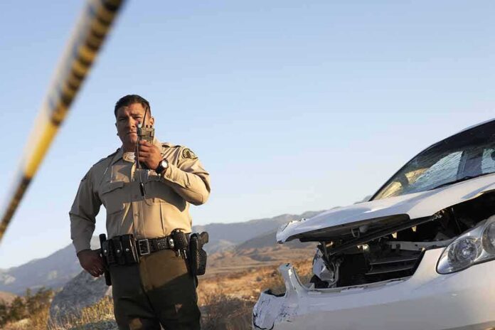 shutterstock_110766821 Police officer at crash scene near damaged white car