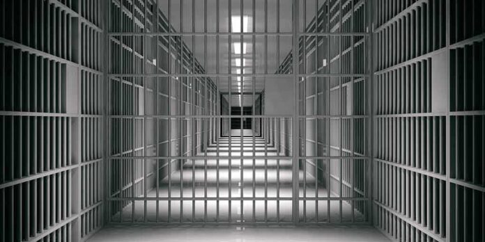 empty prison corridor with barred cells