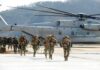 Marines Dangle $15K – But For Who? Soldiers disembark and walk past a large military helicopter