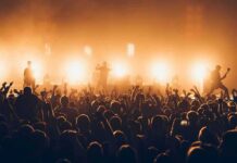 Radio Stations REMOVE Artist Over Controversy – Fans Erupt Rock band performing on stage with bright backlights and cheering crowd