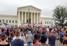 David Givens at a large protest outside a neoclassical courthouse