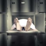 Horror Discovery Made Inside Funeral Home Body on morgue tray with toe tag and sheet