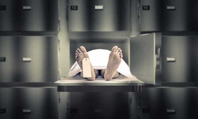 shutterstock_1279100890 Body on morgue tray with toe tag and sheet