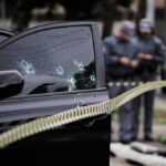Paroled Shooter Unleashes Chaos—Mass Panic! Car door with bullet holes at a taped-off crime scene