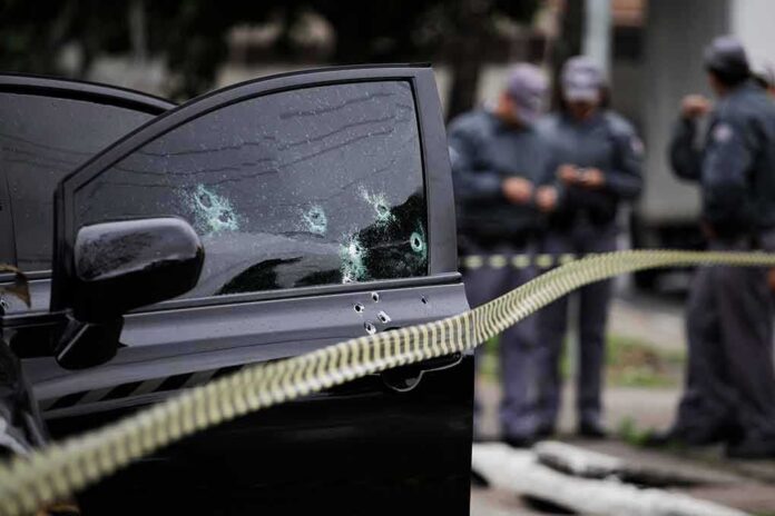 shutterstock_1357161179-1 Car door with bullet holes at a taped-off crime scene