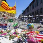 Memorial with flowers and flags by street barricades