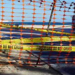 Mystery Orbs Found Spread Out Across Beach Orange safety net and yellow police tape blocking a beach access