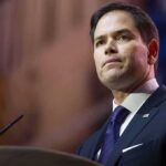 Nazi Meme Torches Rubios TOP Aide man in suit speaking at podium
