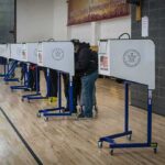 Voters at polling booths in a gymnasium