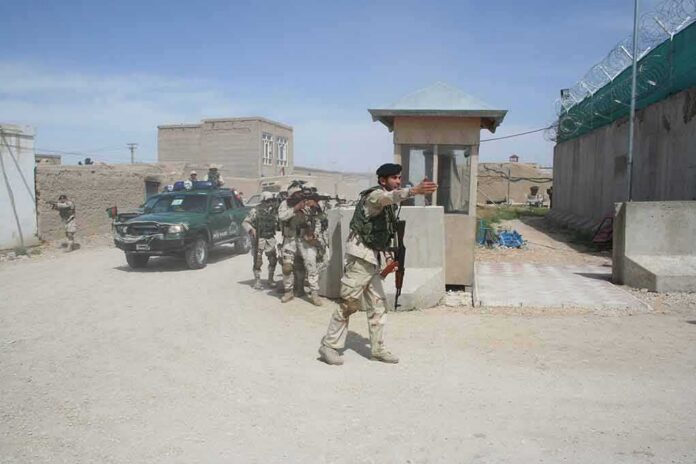 Armed soldiers patrol near a guard post outside a walled compound