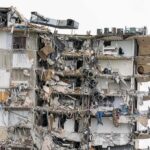Partially collapsed apartment building with exposed rooms and debris