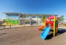 Playground with colorful slide in front of a school building