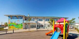 Playground with colorful slide in front of a school building