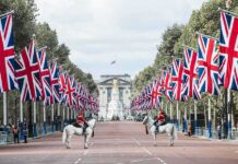Union Jack flags line a broad avenue with mounted guards