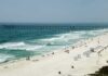 Violent Brawl Over Beach Lounge Leaves Tourist Dead Sandy beach with turquoise waves and a long pier