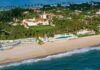 Aerial view of a beachfront estate with pool and palm trees