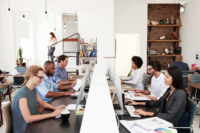 Office workers at shared desks using desktop computers