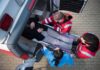 Paramedics load a patient on a stretcher into an ambulance