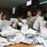 People counting ballots at a table