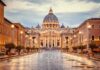 St. Peter's Basilica at the end of a wet street at dusk