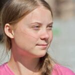 young woman with braid looking to the side outdoors