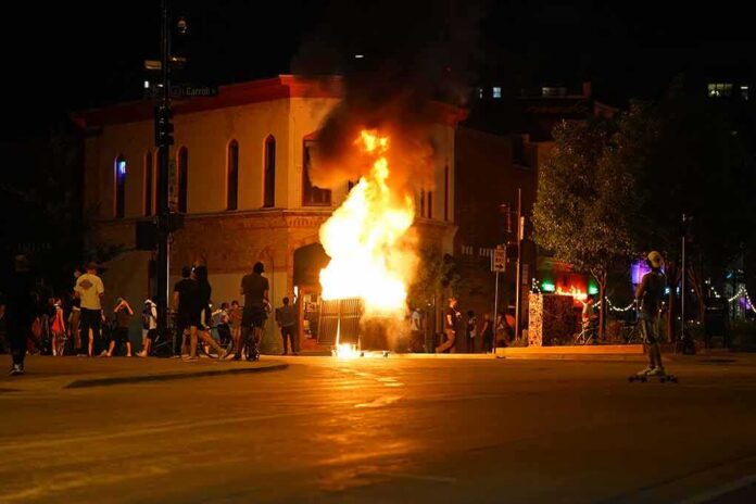 Street fire at night with bystanders near a burning object