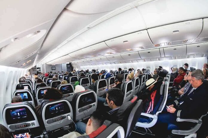 Airplane cabin with passengers seated in economy class