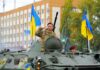 Zelenskyy’s Tells Fox News He’s Ready For Peace Deal Soldiers on armored vehicle with Ukrainian flags