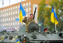 Zelenskyy’s Tells Fox News He’s Ready For Peace Deal Soldiers on armored vehicle with Ukrainian flags