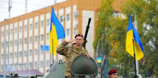 Soldiers on armored vehicle with Ukrainian flags
