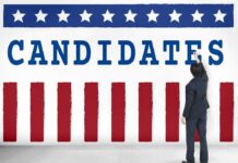Governor Blasts GOP for Supporting Candidate Accused of Child Sexual Assault Man in suit writing on wall with word candidates and patriotic design