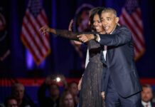 Michelle Obama and Rob Nabors pointing on stage at an event