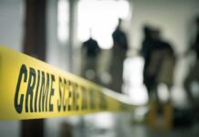 Crime scene tape with investigators in the background