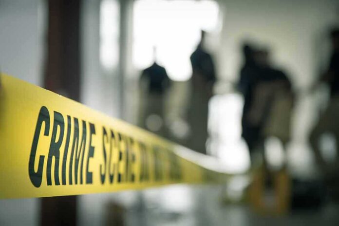 Crime scene tape with investigators in the background