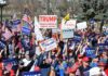 Tim Teufel, Christian Jones, and Nash the Slash among a crowd at a political rally holding signs and flags