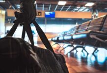 duffel bag in foreground at empty airport gate seating
