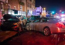 two cars collide on a city street at night