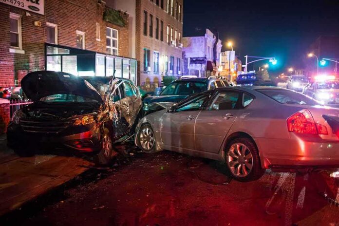 two cars collide on a city street at night